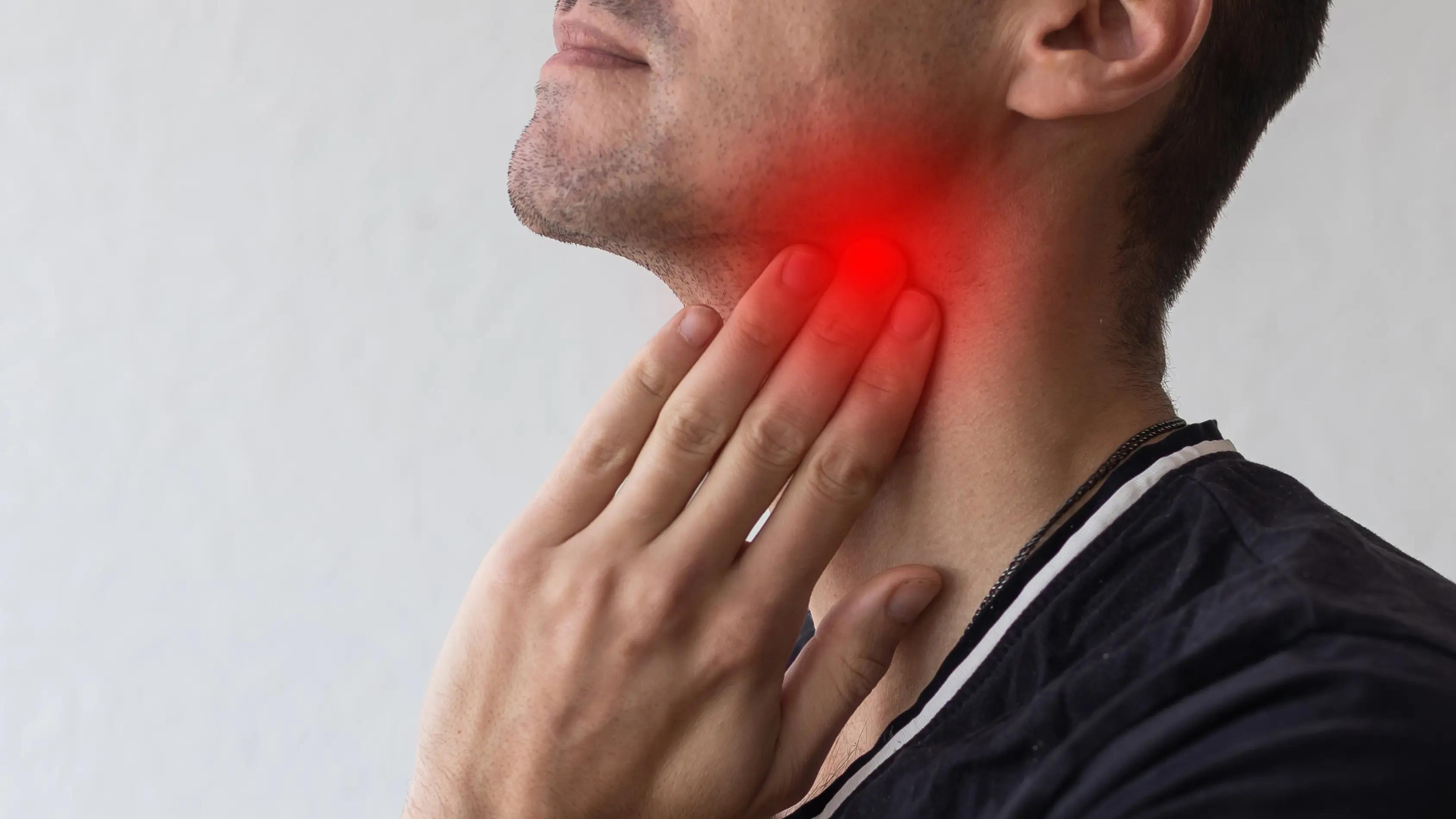 Person holding the side of their neck and weighing two options, illustrating the decision between a stellate ganglion block injection and a non-invasive alternative